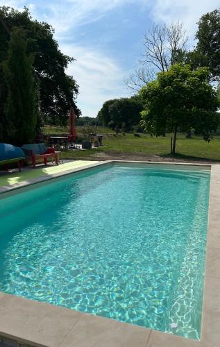une piscine avec de l'eau bleue dans une cour dans l'établissement Domaine de l'Atrée - Gite La Petite Longère dans la Nature Préservée, à Saint-Martin-des-Champs