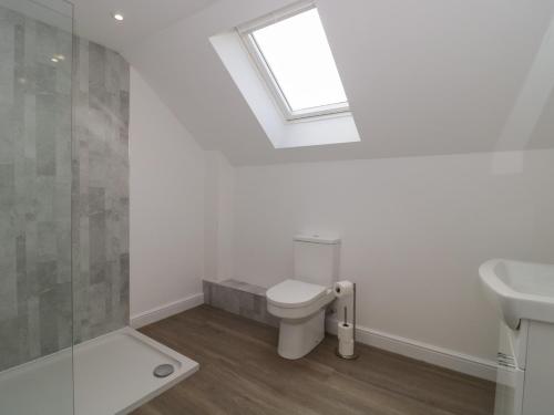 a bathroom with a toilet and a sink and a window at 3 The Stables in Highbridge