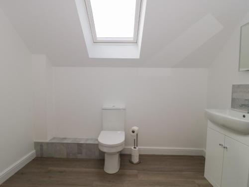 a white bathroom with a toilet and a sink at 3 The Stables in Highbridge
