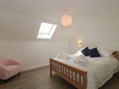 a bedroom with a bed with a window and a chair at 3 The Stables in Highbridge