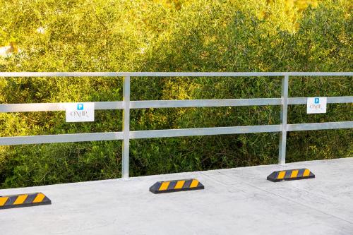 a white fence with signs on it next to a sidewalk at Onar Luxury Suites Parga in Parga