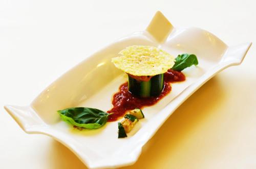 a white plate with a dish with food on it at Hotel Schilcherlandhof in Stainz
