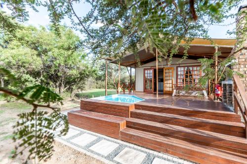 a house with a swimming pool on a deck at Jabula Bush Camp in Klipdrift