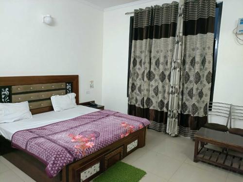 a bedroom with a bed and a window with curtains at Collection O Shri Mata Vaishno Devi Railway Junction Formerly Sai Mahal in Katra