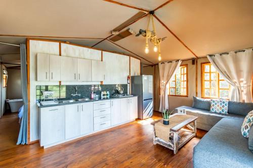a kitchen and living room with a couch and a table at Jabula Bush Camp in Klipdrift