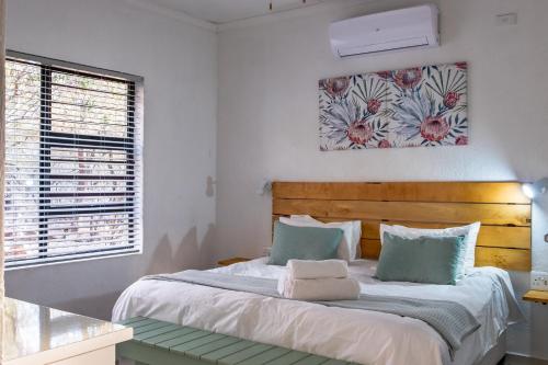 a bedroom with a bed and a painting on the wall at Gemsbok Place in Marloth Park