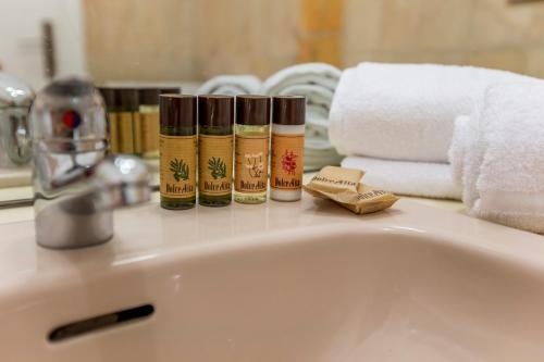 - un lavabo avec 3 bouteilles d'eau et des serviettes dans l'établissement Appartement et Parking Cannes Center by Connexion, à Cannes