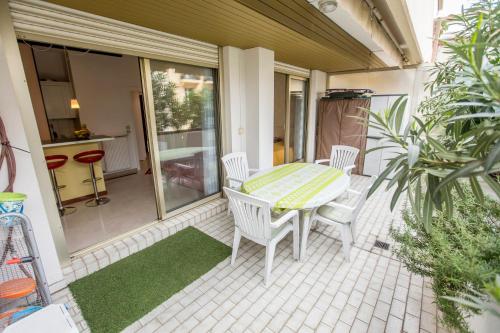 un patio avec une table et des chaises sur un porche dans l'établissement Appartement et Parking Cannes Center by Connexion, à Cannes