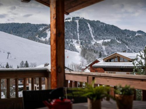 - une vue sur une montagne enneigée depuis une terrasse couverte dans l'établissement Chalet Le San Marco - OVO Network, à La Clusaz