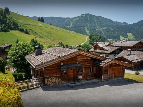 a large wooden house with a mountain in the background at Chalet Le San Marco - OVO Network in La Clusaz