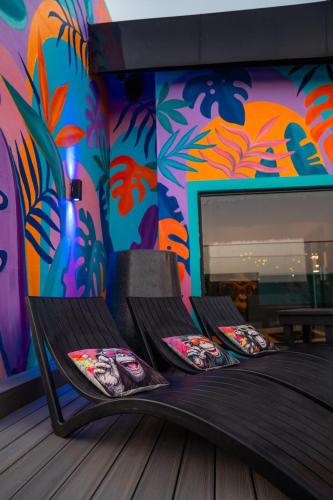 a room with a bed with a colorful wall at Zar Hotel in Amanzimtoti