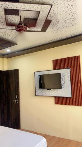a room with a tv on a wall at hotelsunwhite in Faridabad