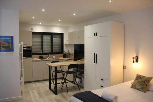Il comprend une chambre avec un lit et une cuisine avec un bureau. dans l'établissement Foch - Studio - Calme - wifi, à Vannes