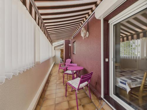 une rangée de chaises et de tables violettes dans une pièce dans l'établissement 550m de la plage au centre d'Andernos - pour 4, à Andernos-les-Bains