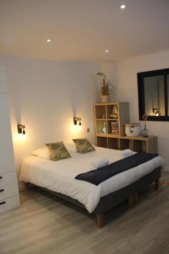 une chambre avec un grand lit avec un miroir dans l'établissement Foch - Studio - Calme - wifi, à Vannes