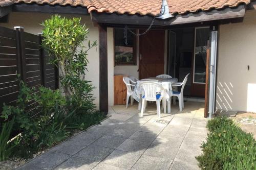 une table et des chaises sur le patio d'une maison dans l'établissement Little house with terrace on the oceanfront, à Moliets-et-Maa