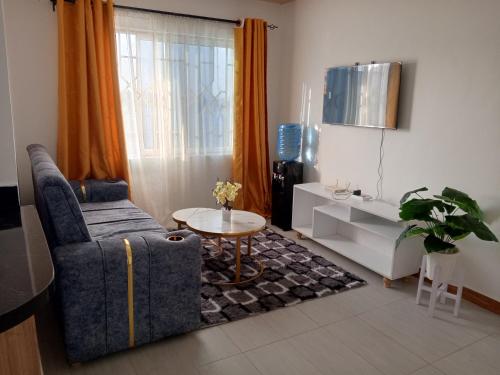 a living room with a couch and a table at Luqman Apartments in Meru