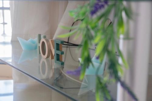 a glass table with a sign and a plant at Elysia Park Apartments in Paphos City