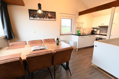 a kitchen and dining room with a wooden table and chairs at Holiday Park La Sapinière in Hosingen
