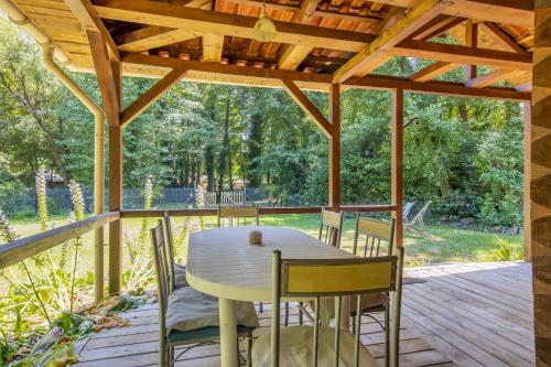- une terrasse couverte en bois avec une table et des chaises dans l'établissement Villa compostelle, à Grayan-et-lʼHôpital