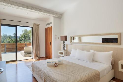 une chambre blanche avec un lit et un balcon dans l'établissement Villa Fortune, Saint-Tropez, à Saint-Tropez
