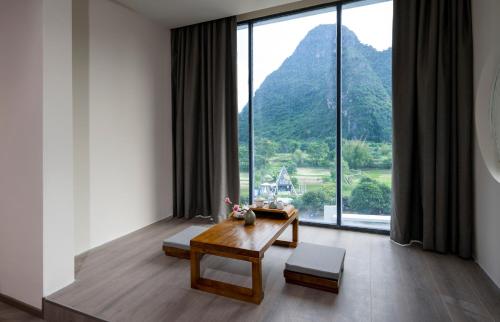 a living room with a table and a large window at Yangshuo-Greenery Retreat in Yangshuo