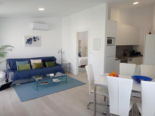 a living room with a blue couch and a table at LAR JARDÍN - Casas con parking privado in Santiago de Compostela