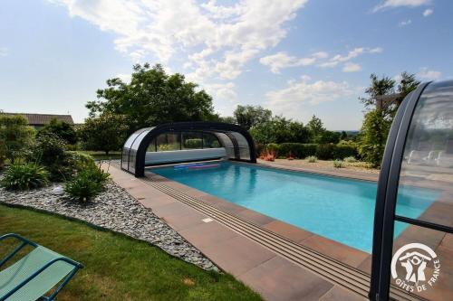 a swimming pool in a yard with a bridge over it at Le ruset in Saint-Donan