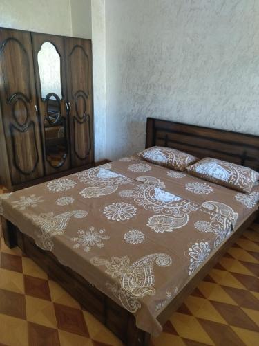 a bed in a room with a wooden bed frame at White House Avtandil&Nino in Sarpi