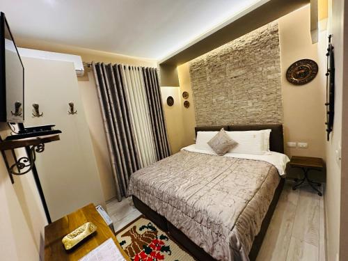 a hotel room with a bed and a brick wall at Vila Eden Boutique Hotel in Korçë