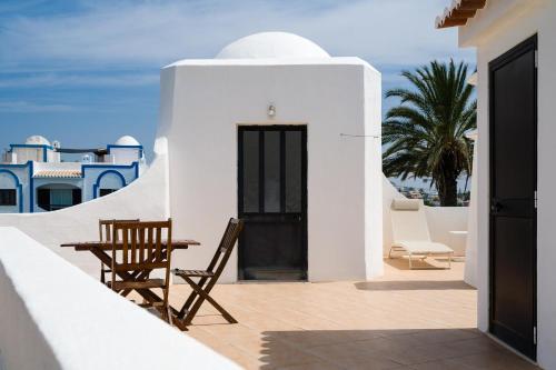 a balcony with chairs and a table on a building at 3-Bed Clifftop Beach House - Pool, Private Garden, Rooftop & Paddle Boards in Porches