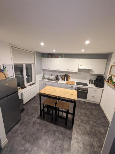 une cuisine avec des armoires blanches et une table en bois dans l'établissement Crôque d'Opale, à Ambleteuse