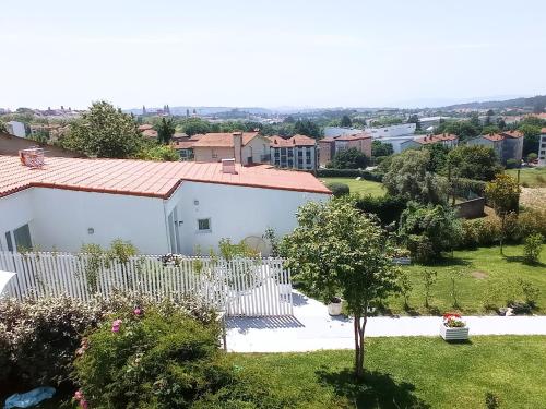 una casa blanca con una valla blanca en Casas turísticas Lar Jardín - Parking privado, en Santiago de Compostela