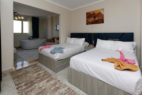 a hotel room with two beds and a bathroom at Luxury Panorama pyramids & jacuzzi in Cairo