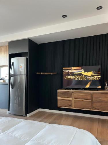 a kitchen with a refrigerator and a black wall at Ammonite Playa in Mar del Plata