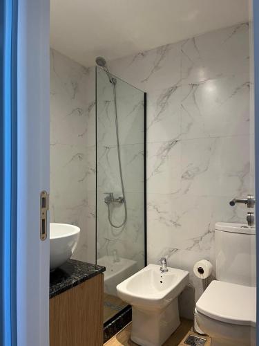 a bathroom with a shower and a toilet and a sink at Ammonite Playa in Mar del Plata