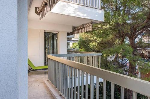 un balcon vide d'une maison avec un arbre dans l'établissement L'ESTEREL avec piscine et grand balcon vue mer aperçu, à Cannes