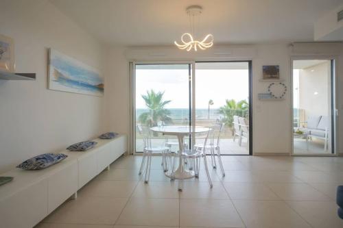 une salle à manger avec une table et une vue sur l'océan dans l'établissement Valras-Loc Archipel Capri Evasion avec Vue sur Mer, à Valras-Plage