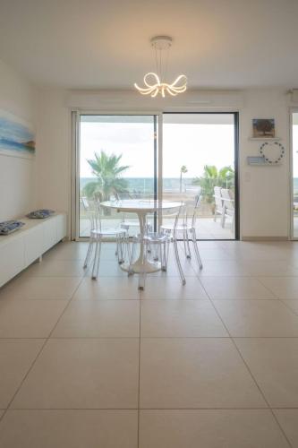 une salle à manger avec une table et une vue sur l'océan dans l'établissement Valras-Loc Archipel Capri Evasion avec Vue sur Mer, à Valras-Plage