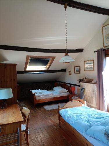 une chambre avec deux lits et une table et des chaises dans l'établissement La Bergerie, à Étretat