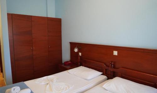 a bedroom with a bed with a wooden headboard at Blue Bay Hotel in Karpathos Town