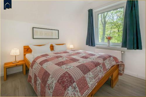 a bedroom with a bed and a window at Ferienanlage Seeblick Meerchen in Ostseebad Koserow