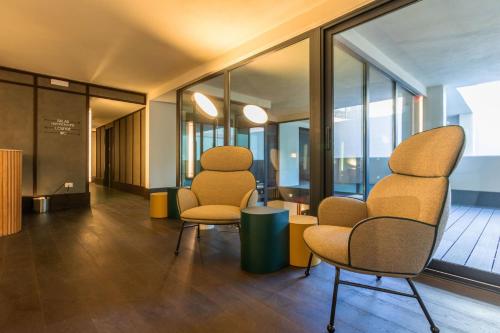 two chairs and a table in a room with windows at Onix Fira in Barcelona