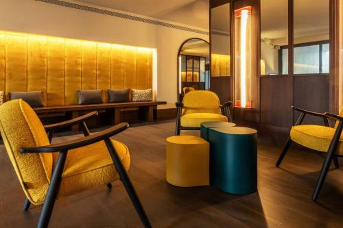 a waiting room with chairs and a table andools at Onix Fira in Barcelona