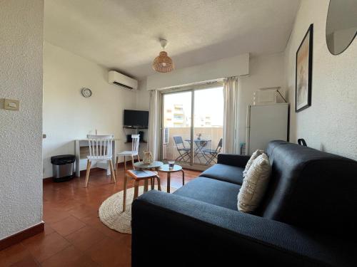 a living room with a blue couch and a table at Studio proche plage et centre-ville in Sainte-Maxime