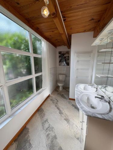 a bathroom with two sinks and a window at Gîte et Roulotte dans les Vosges in Remiremont