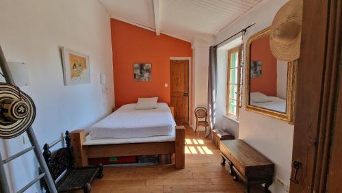 une chambre avec un lit dans une pièce aux murs orange dans l'établissement Un petit coin de tranquile près de la mer, à Vallauris