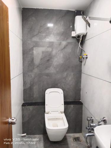 a bathroom with a toilet and a sink at Hotel Metro AC Room in Vadodara