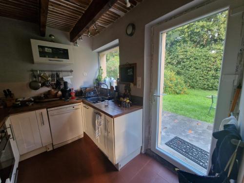 une cuisine avec un évier et une grande porte coulissante en verre. dans l'établissement Un petit coin de tranquile près de la mer, à Vallauris