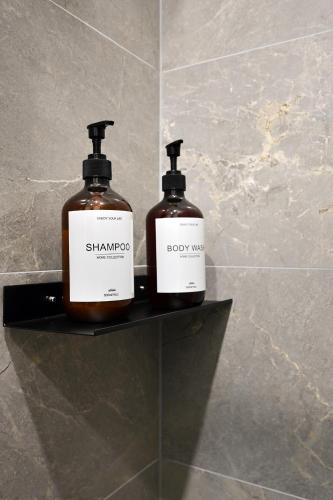 two bottles of soap sitting on a shelf in a bathroom at Historical House Apartments in Rīga